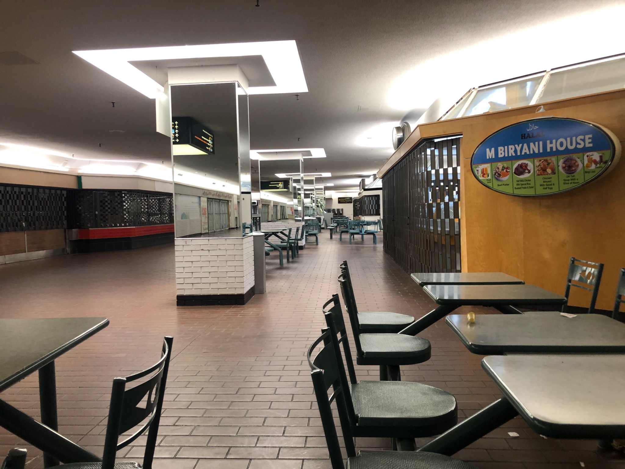 Nearly deserted Cumberland Terrace food court in Toronto, with the M Biryani House restaurant sign visible.